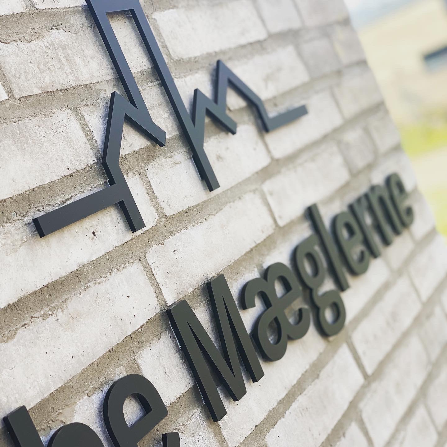 Elegant og stilfuldt facadelogo monteret på husmur, specialfremstillet for Ribe Mæglerne af Skiltefabrikken.nu.