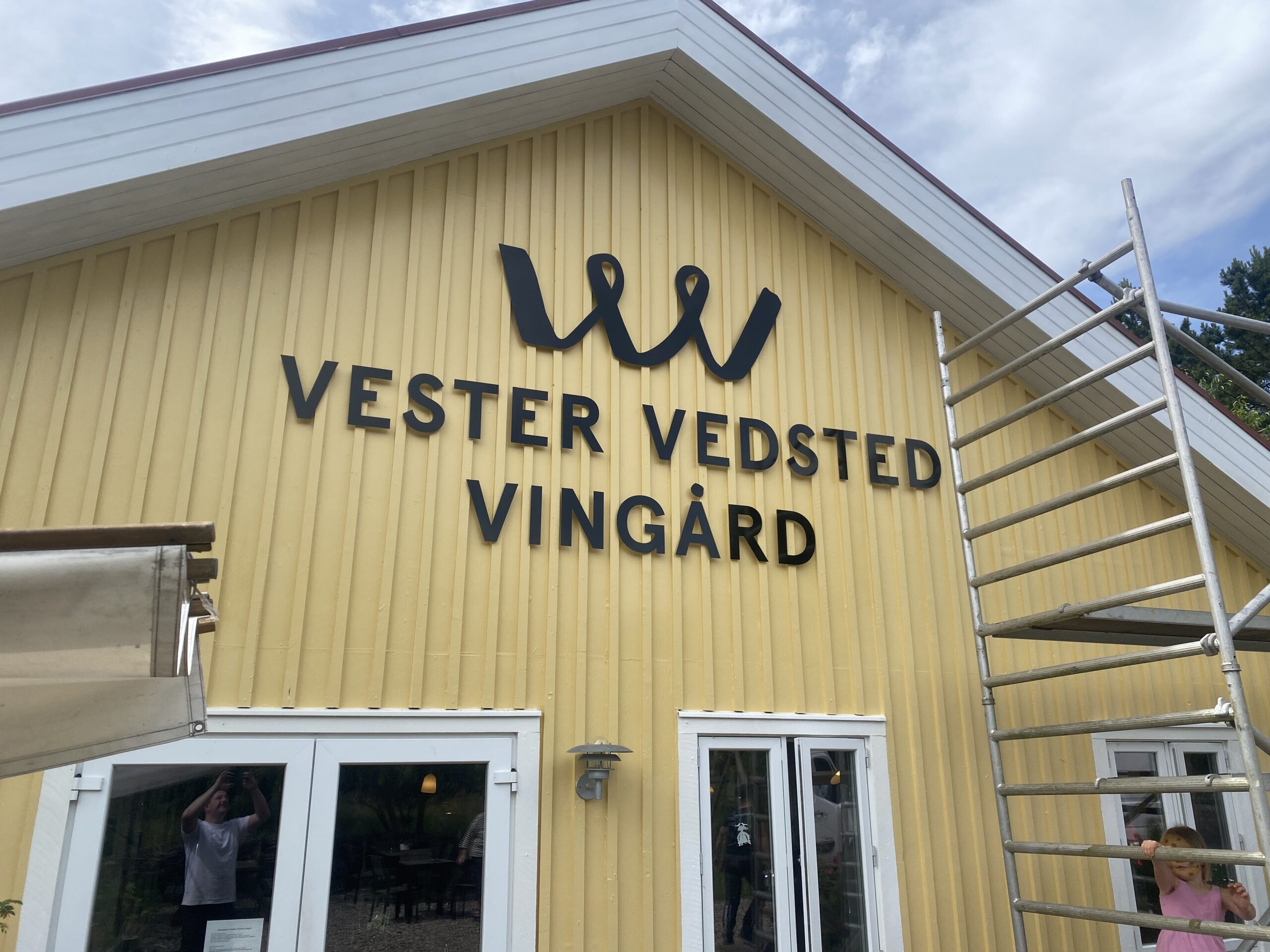 Facadebogstaver med navn og logo monteret på bygningen hos Vester Vedsted Vingård.