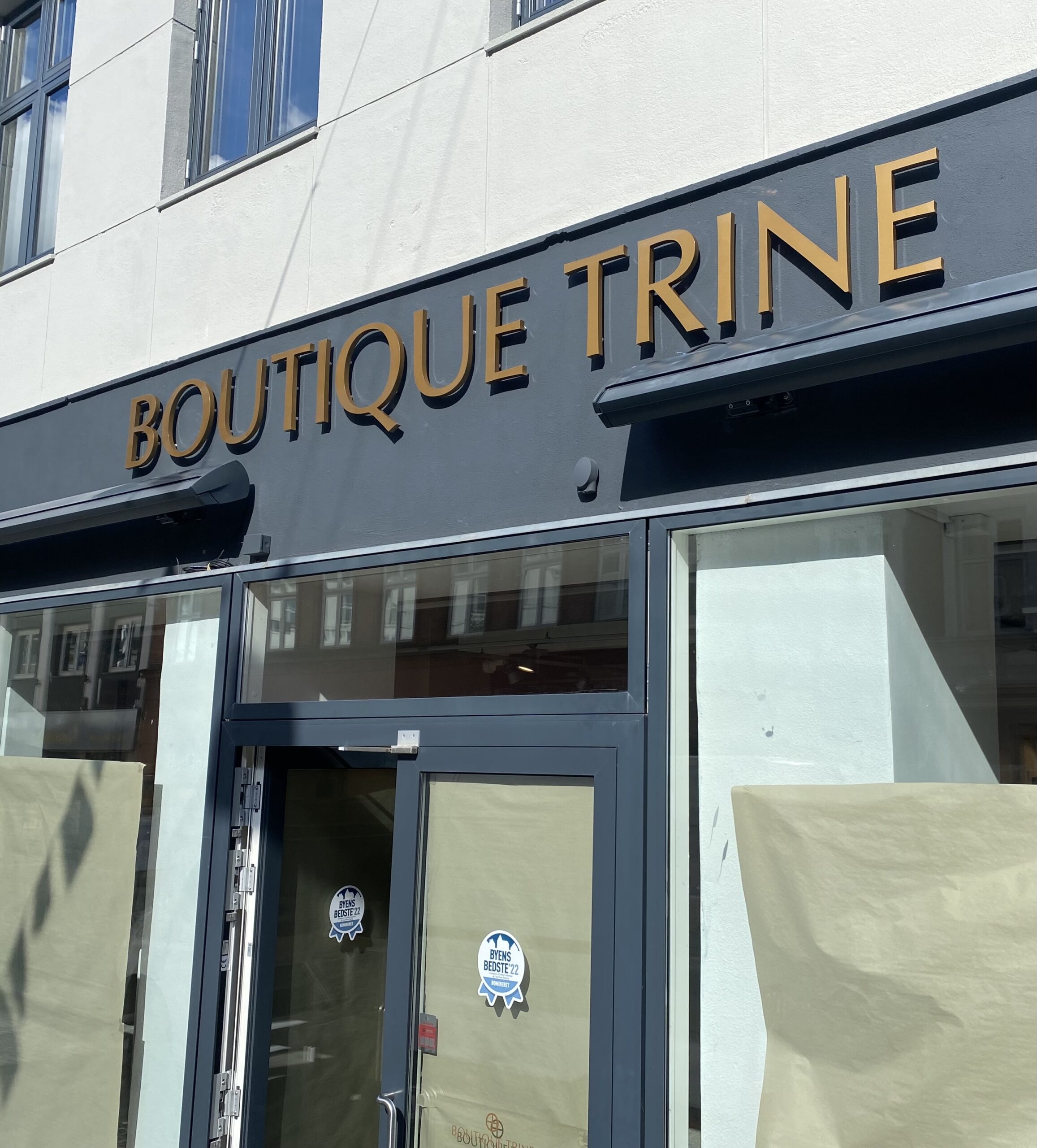 Elegant butiksskilt monteret på tøjbutikken Boutique Trine, skaber høj synlighed på gågaden i Esbjerg. 