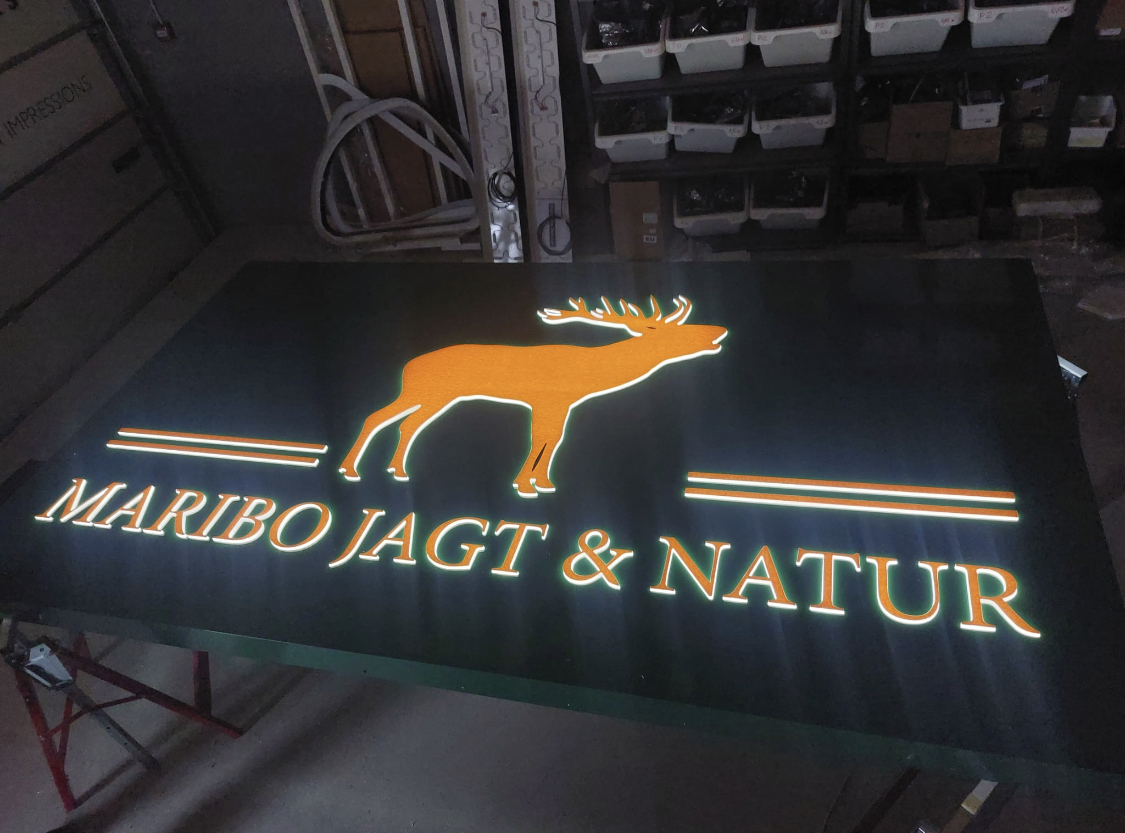 Oplyst facadeskilt med integreret LED og markant grafisk motiv, produceret til Maribo Jagt & Natur.