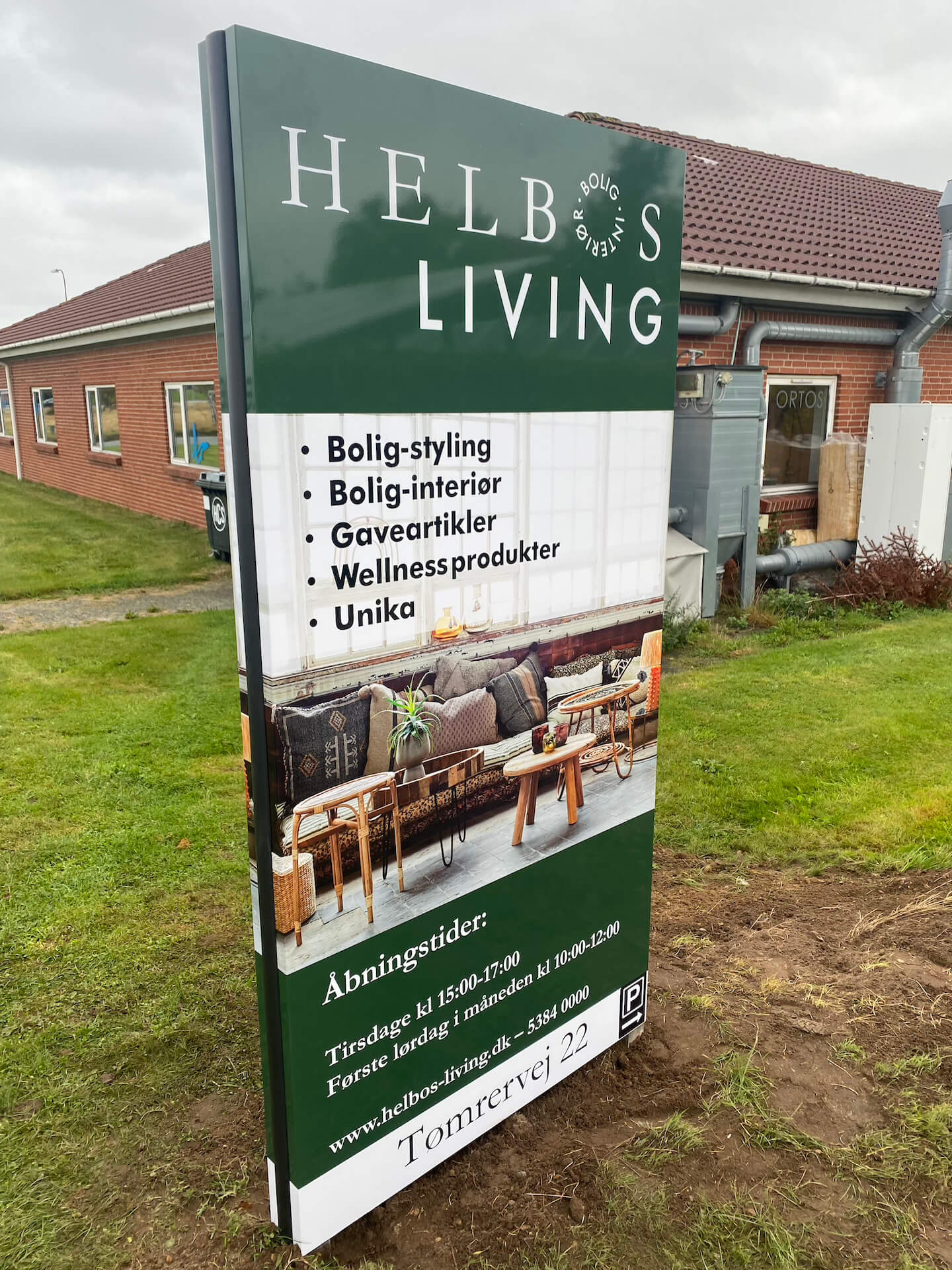 Dobbeltsidet skiltepylon placeret ved Helbos Living med tydelig branding og høj synlighed.